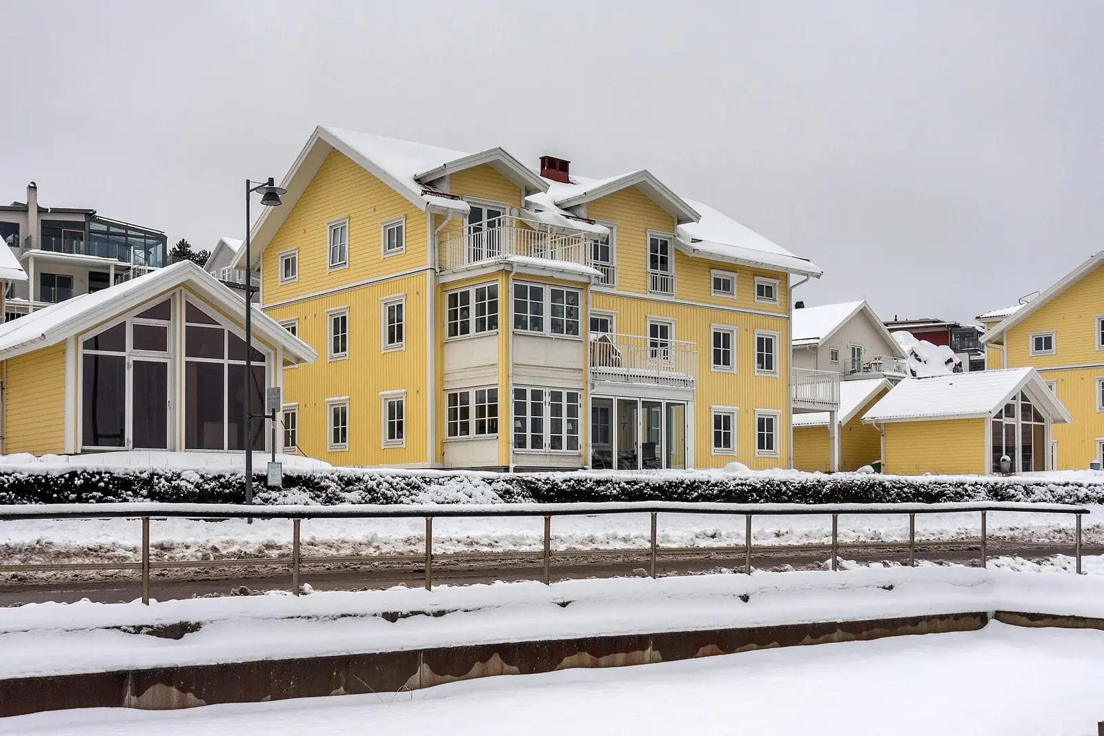 Gula trähus i snö vid en hamn på västkusten